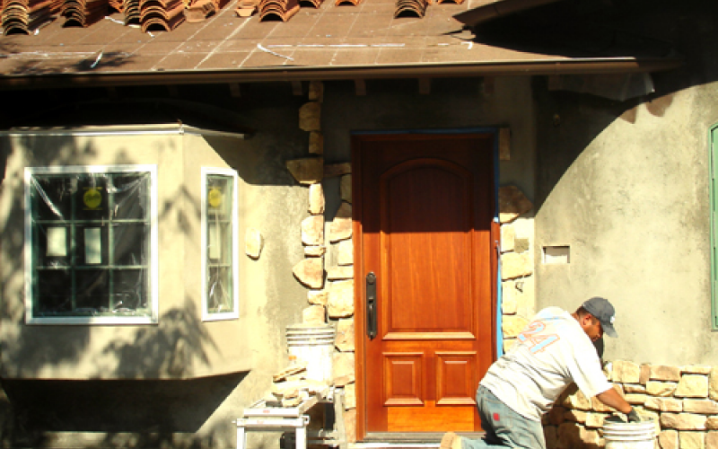 Stones being affixed to the walls of the home